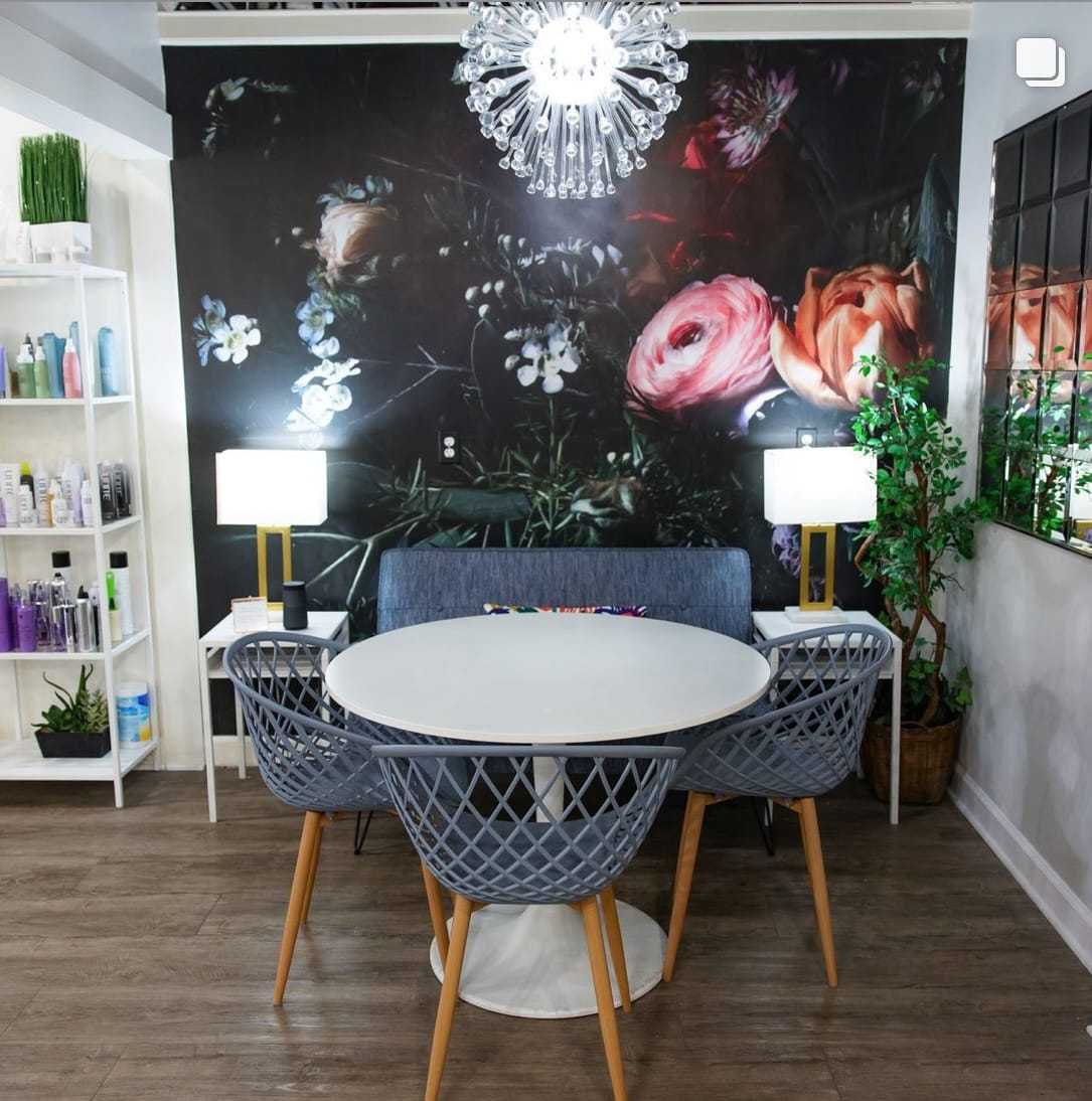 Stylish interior with floral wall, modern lighting, and dining set.